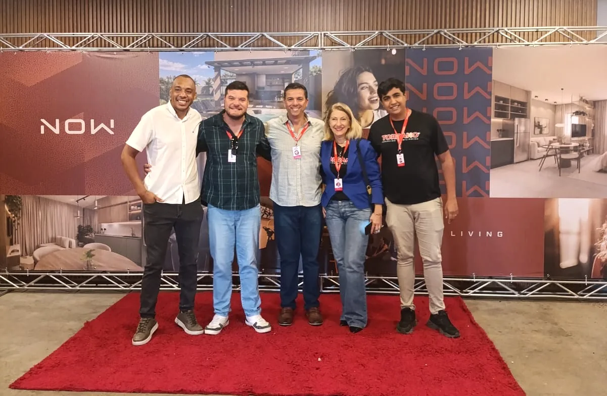 Parte da equipe da Torrano Negocios Imobiliarios no lancamento do NOW Living, da Vitta, diante do painel do empreendimento