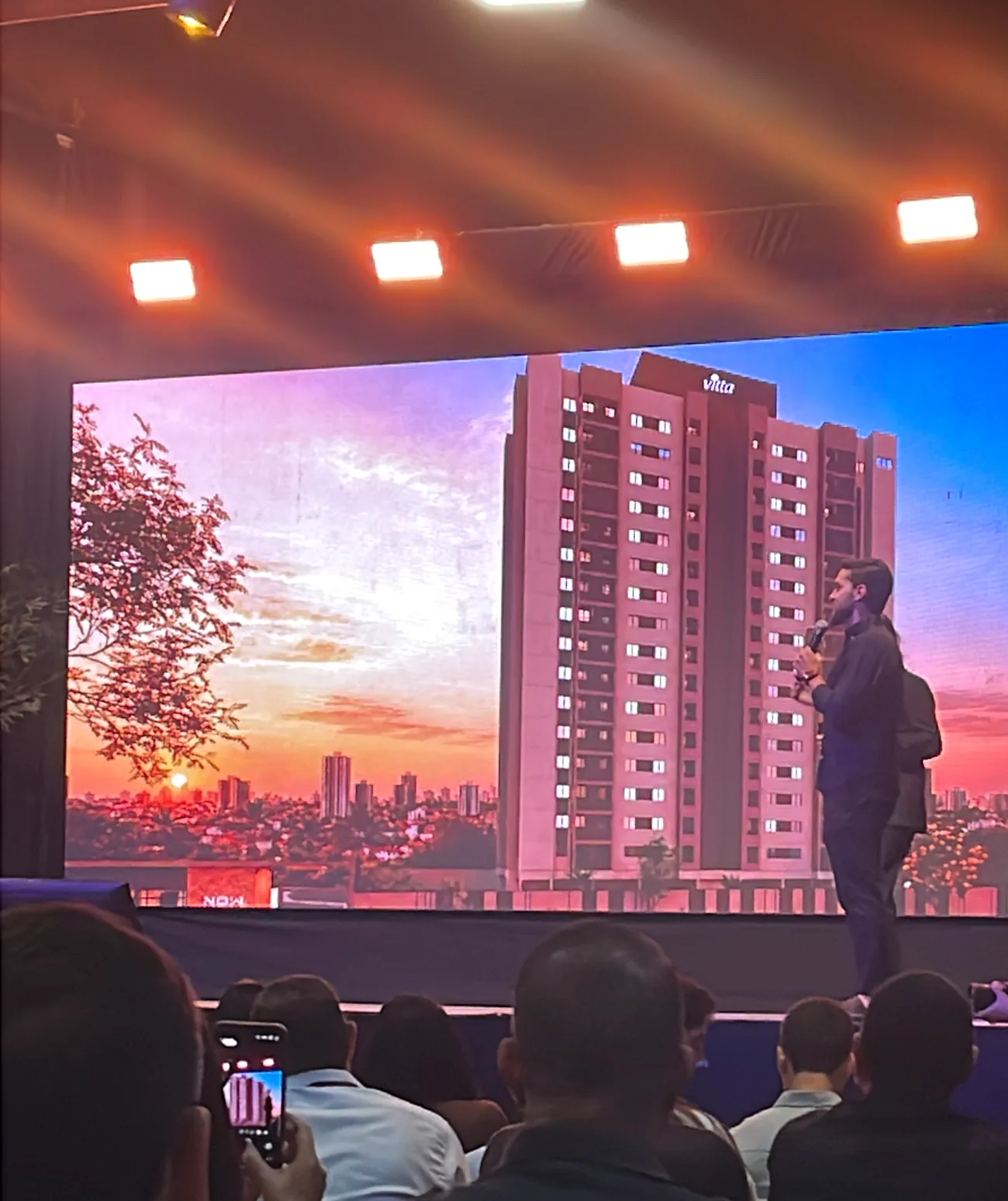 Plateia do lancamento do NOW Living durante a apresentacao da torre no telao, em Uberlandia