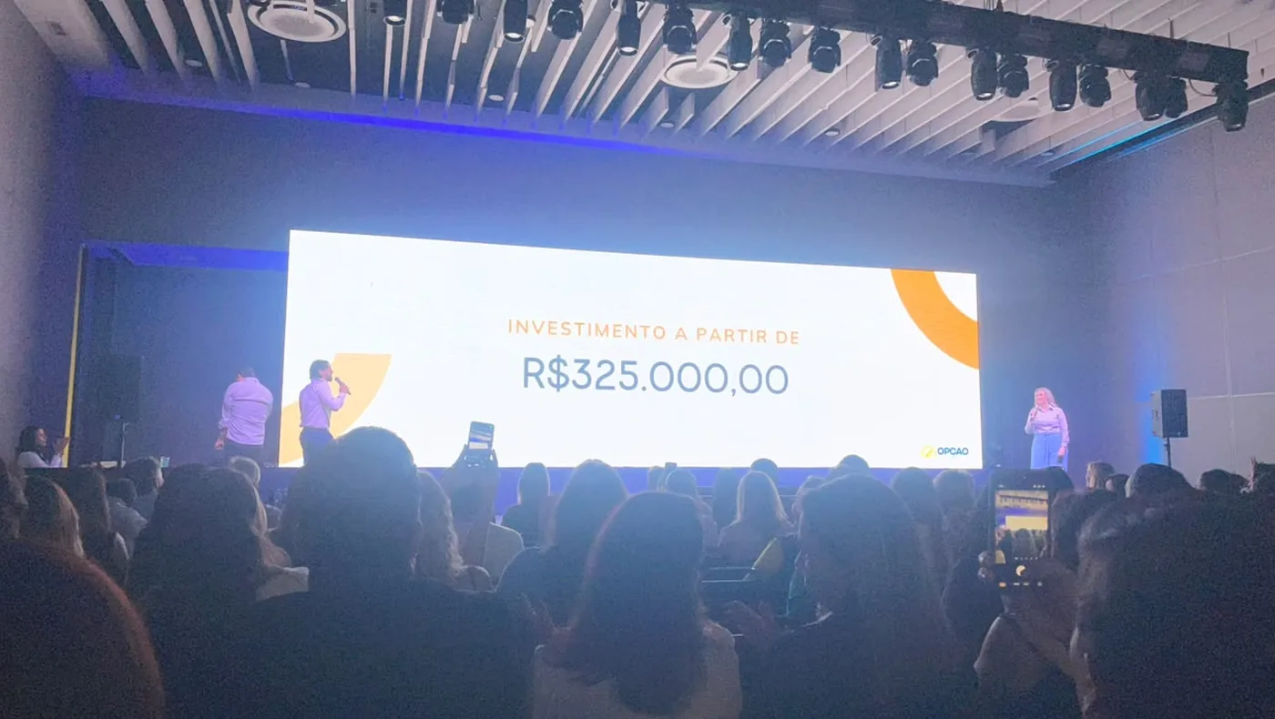 Evento de lançamento do Opção Studios em Uberlândia, com a apresentação do valor de investimento no telão