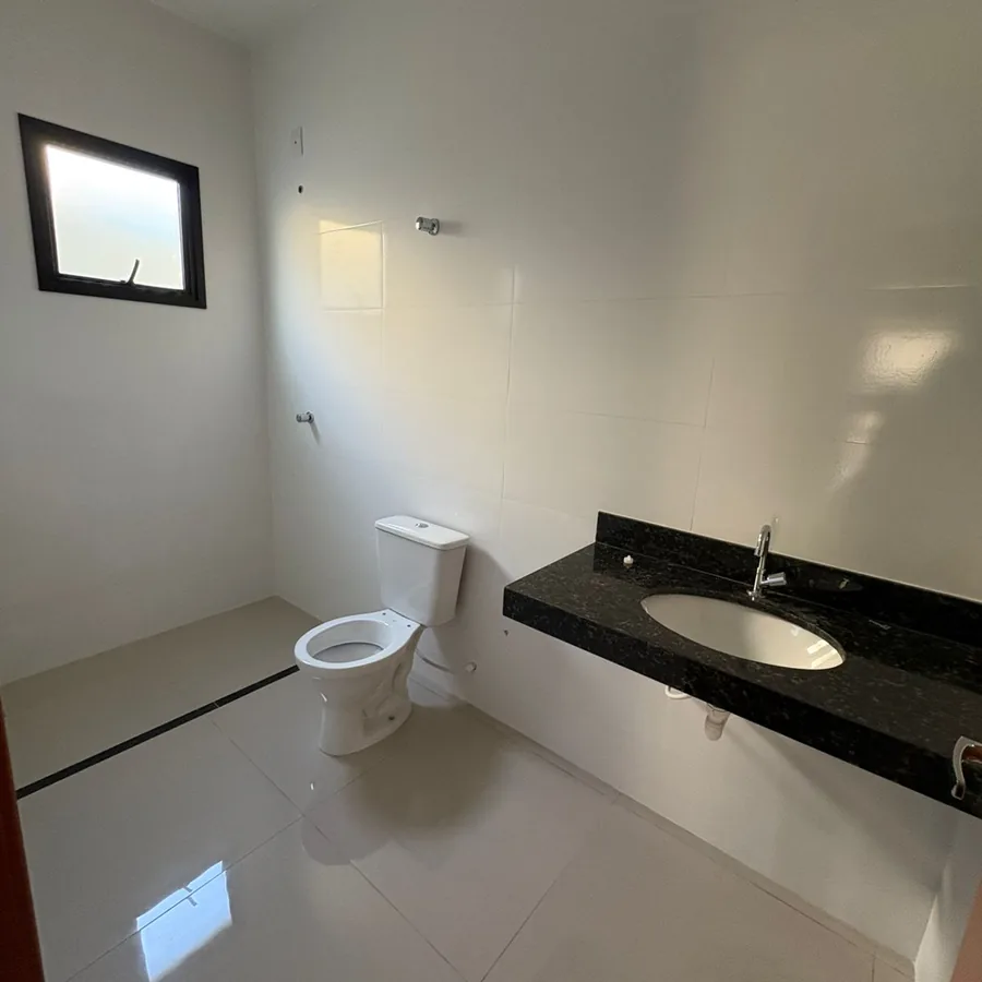 Foto real do banheiro da suíte, com bancada de granito, em uma casa do Residencial Gomes & Carvalho