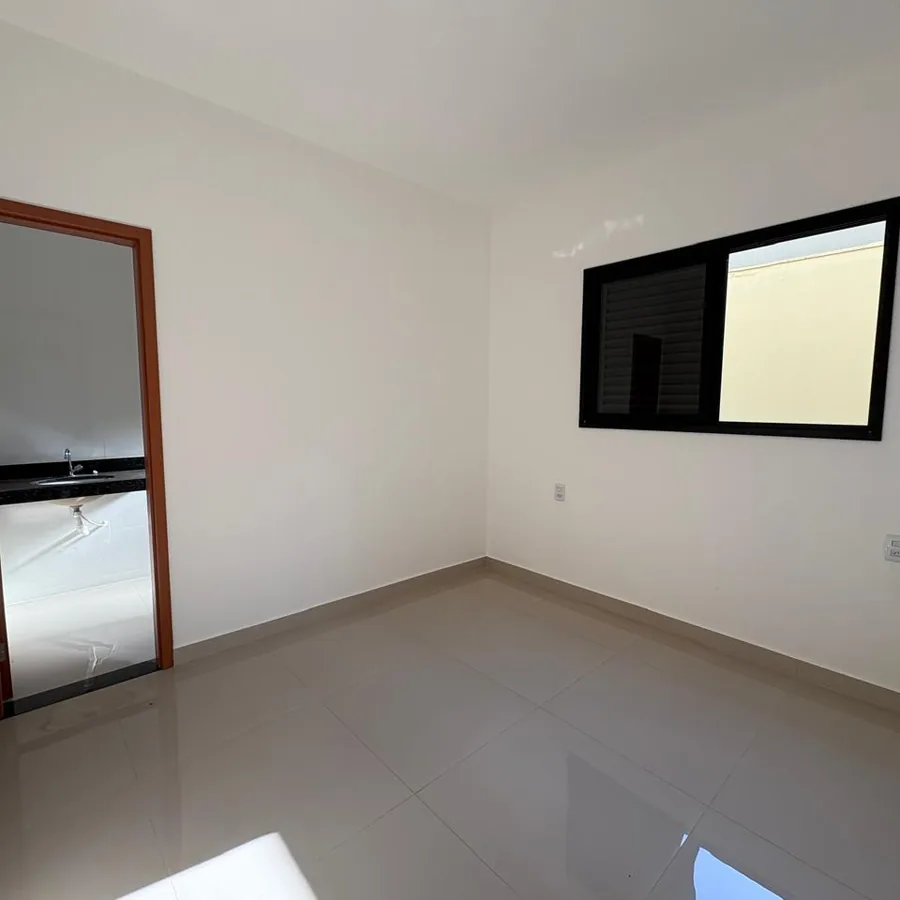Foto real da suíte de uma casa do Residencial Gomes & Carvalho, com porta do banheiro e janela