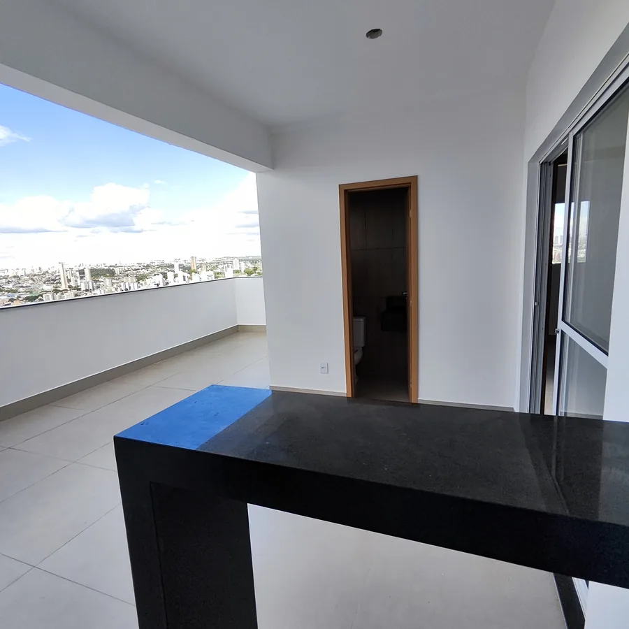 Foto real do terraço descoberto de uma cobertura do Vista Reale, com bancada de granito e vista da cidade